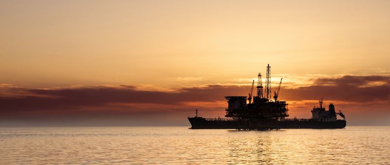 An offshore oil platform at sunset